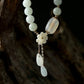 Light green jade bead necklace with translucent agate centerpiece, gold plum blossom charm, and jade-amethyst teardrop pendants