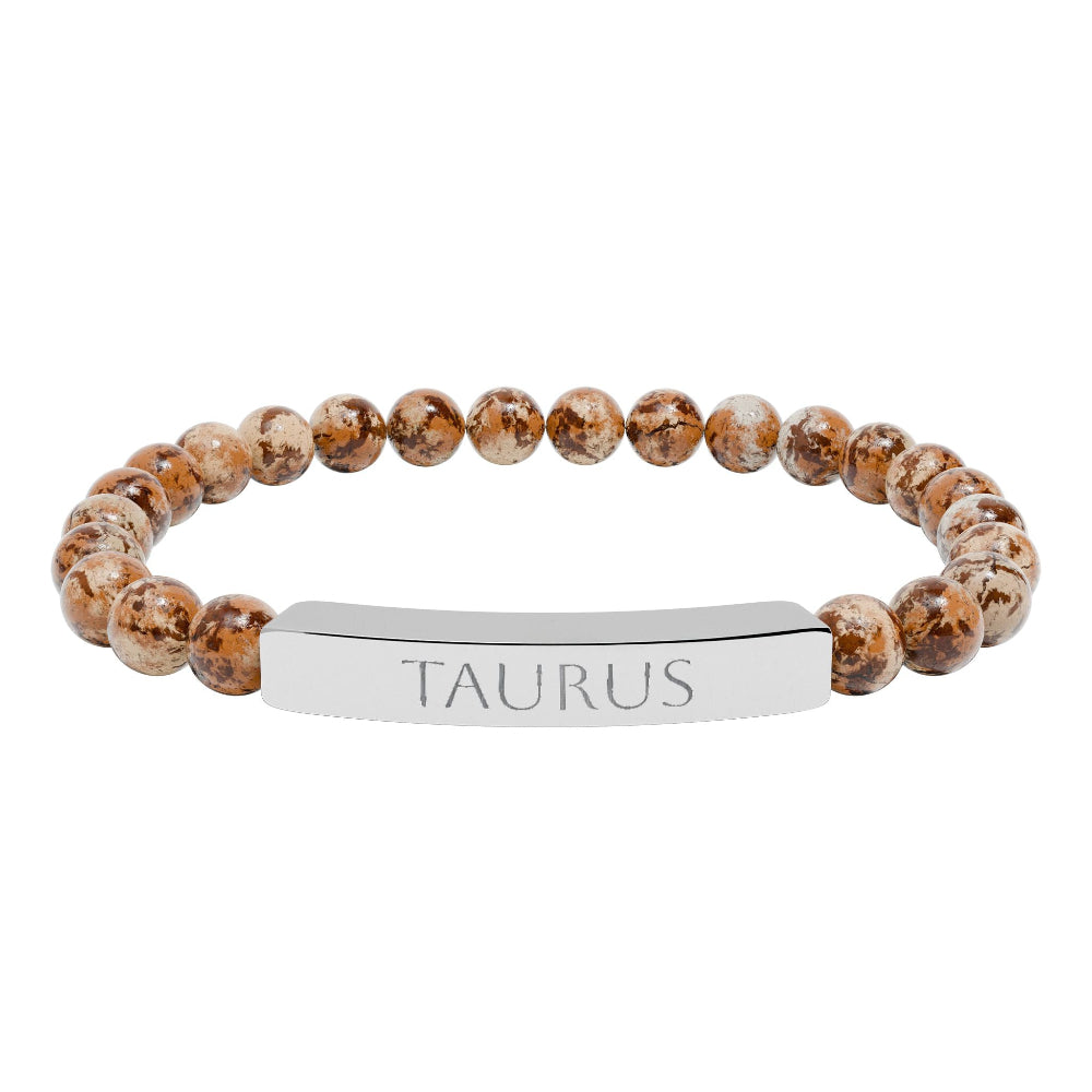 Bracelet with polished leopard jasper beads in earthy brown tones with natural veining, paired with a silver curved bar engraved "TAURUS" in uppercase letters. Stretch-fit zodiac-inspired crystal jewelry.