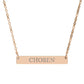 Rose gold bar necklace with engraved uppercase text "CHOSEN" on a sleek matte pendant, suspended on a delicate matching rose gold chain. Minimalist motivational affirmation jewelry for empowerment and self-worth.