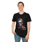 Black unisex cotton t-shirt modeled by smiling man with hand in pocket, featuring bold "Primal" graphic: stylized intense man portrait wearing dark sunglasses, short styled hair, vibrant multicolored geometric face in red, orange, teal, and blue tones, dynamic paint splatters bursting outward. Elegant white cursive "Primal" text below. Primal masculine energy motivational crewneck tee.