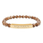 Bracelet with polished leopard jasper beads in earthy brown tones with natural veining, featuring a gold-plated curved bar engraved "AQUARIUS" in uppercase letters. Stretch-fit zodiac-inspired crystal jewelry.