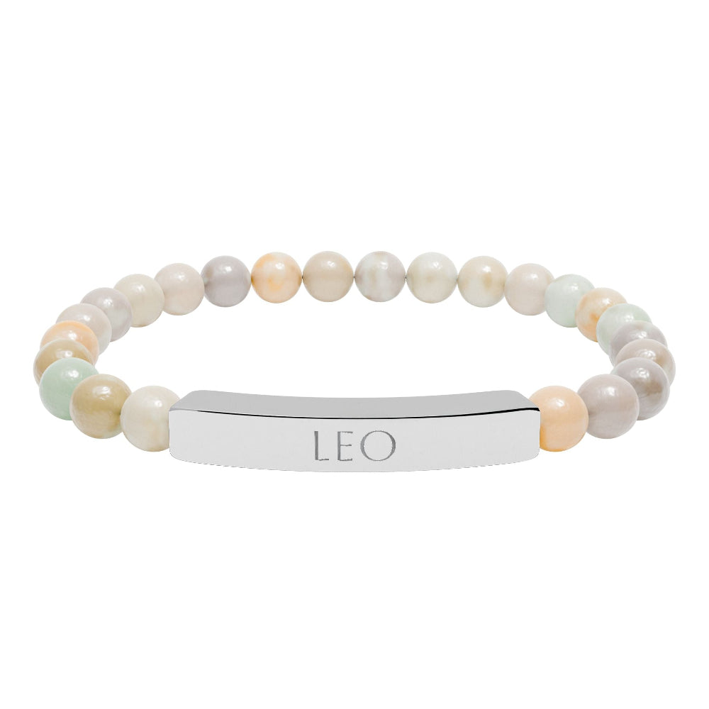 Bracelet with polished pastel beads in soft peach, cream, gray, and light blue tones with natural marbling, featuring a silver curved bar engraved "LEO" in uppercase letters. Stretch-fit zodiac-inspired crystal jewelry.