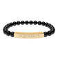 Bracelet with polished black onyx beads and gold-plated curved bar engraved "AQUARIUS" in uppercase letters. Stretch-fit zodiac-inspired crystal jewelry.
