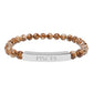Bracelet with polished leopard jasper beads in earthy brown tones with natural veining, featuring a silver curved bar engraved "PISCES" in uppercase letters. Stretch-fit zodiac-inspired crystal jewelry.