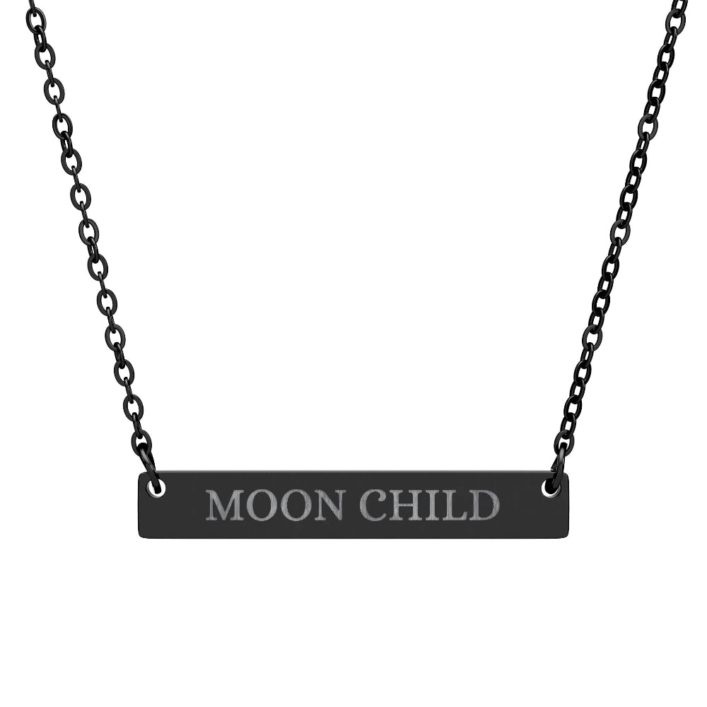 Black bar necklace with engraved uppercase text "MOON CHILD" on a matte black pendant, suspended on a delicate black chain. Minimalist spiritual affirmation jewelry for lunar energy, intuition, and cosmic connection.