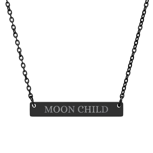 Black bar necklace with engraved uppercase text "MOON CHILD" on a matte black pendant, suspended on a delicate black chain. Minimalist spiritual affirmation jewelry for lunar energy, intuition, and cosmic connection.