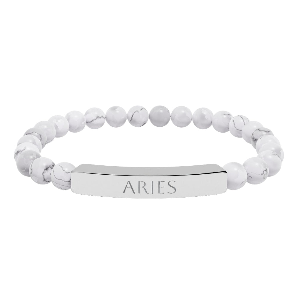 Bracelet with polished white howlite beads featuring natural gray-black veining and marbling, paired with a silver curved bar engraved "ARIES" in uppercase letters. Stretch-fit zodiac-inspired crystal jewelry.