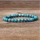 Blue apatite gemstone bracelet on wooden background: polished round beads in vibrant turquoise-blue with natural cloudy inclusions, shiny faceted surfaces, and subtle chatoyancy. Natural healing crystal jewelry for throat chakra, communication, and emotional clarity.