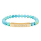 Bracelet with polished turquoise beads in soft aqua-blue tones with natural veining and speckles, featuring a gold-plated curved bar engraved "SCORPIO" in uppercase letters. Stretch-fit zodiac-inspired crystal jewelry for intensity, transformation, and emotional depth.