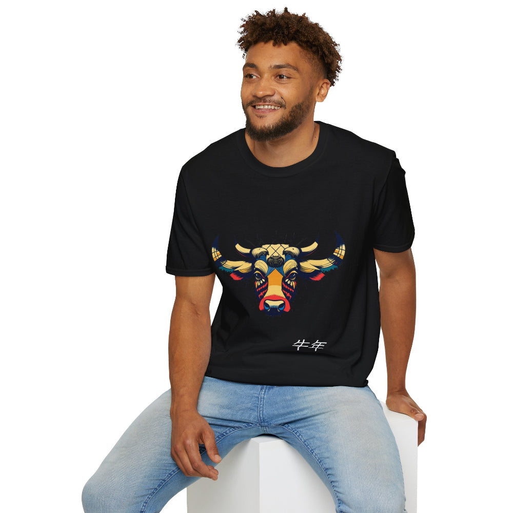 Black unisex cotton t-shirt modeled by smiling man with curly hair and beard, featuring bold Year of the Ox graphic: vibrant abstract ox/bull face portrait with large curved horns, intense eyes, geometric patterns, and dynamic multicolored paint splatters in gold, red, blue, teal, and black tones exploding outward. Chinese text "牛年" (Year of the Ox) printed below in white. Zodiac Chinese New Year motivational crewneck tee.