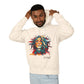 Young man with short hair pulling up the hood of a cream hoodie featuring vibrant artistic portrait of a fierce woman with curly multicolored flowing hair, teal red blue orange face accents, large hoop earrings, third-eye symbol, "Feral" text below