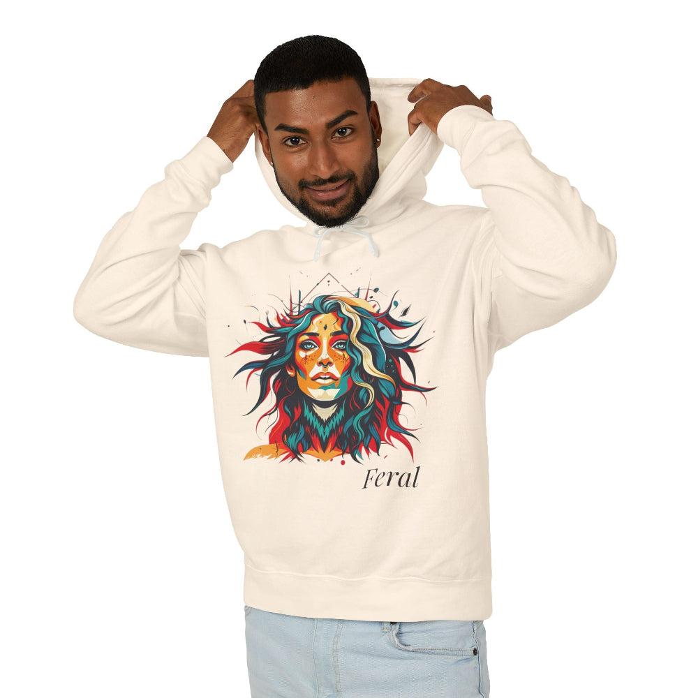 Young man with short hair pulling up the hood of a cream hoodie featuring vibrant artistic portrait of a fierce woman with curly multicolored flowing hair, teal red blue orange face accents, large hoop earrings, third-eye symbol, "Feral" text below