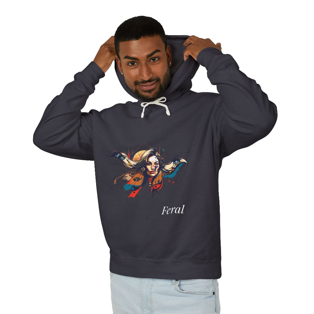 Young man with short hair pulling up the hood of a dark gray hoodie featuring vibrant artistic portrait of a fierce woman with long flowing hair, bold colorful makeup, multicolored splash effects, geometric sun backdrop, "Feral" text below
