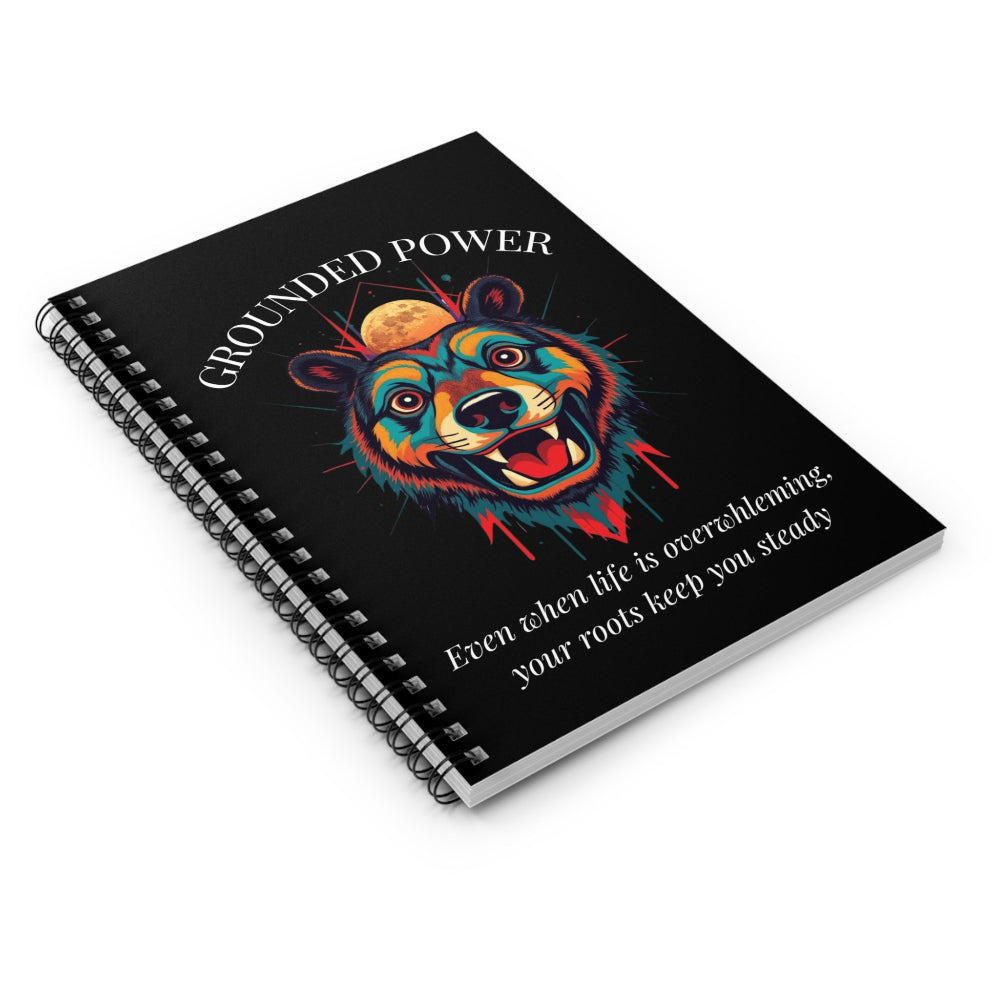Notebook with a colorful abstract bear head portrait, intense expression, flowing mane, geometric accents, and paint splatters on a black background, featuring the words "GROUNDED POWER" and quote "Even when life is overwhelming, your roots keep you steady".