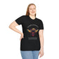 Black plus-size unisex cotton t-shirt modeled by smiling woman with long blonde hair, hand on hip, featuring bold "Sacred Alignment" graphic on chest: vibrant abstract bee with detailed wings and body, colorful geometric accents, and dynamic paint splatters in red, orange, teal, blue, and gold tones around an orange moon. Arched white text "SACRED ALIGNMENT" above and smaller quote "Even when progress is quiet, the harvest is still forming" below. Motivational spiritual empowerment crewneck tee.