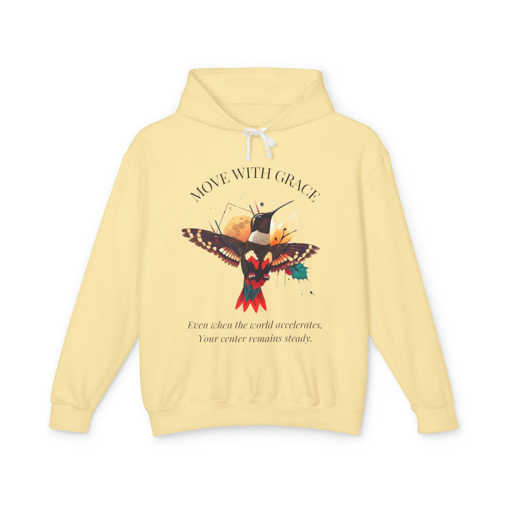 Yellow hoodie with 'Move With Grace' inspirational hummingbird graphic and quote 'Even when the world accelerates, Your center remains steady' printed on the front.