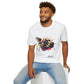 White unisex cotton t-shirt modeled by smiling man with curly hair and beard, seated pose, featuring bold Year of the Dog zodiac graphic: vibrant abstract dog face portrait with intense glowing eyes, detailed fur texture, alert playful expression, geometric accents, and dynamic multicolored paint splatters in gold, red, black, blue, teal, and orange tones exploding outward. Chinese text "狗年" (Year of the Dog) printed below in black. Chinese New Year zodiac motivational crewneck tee.