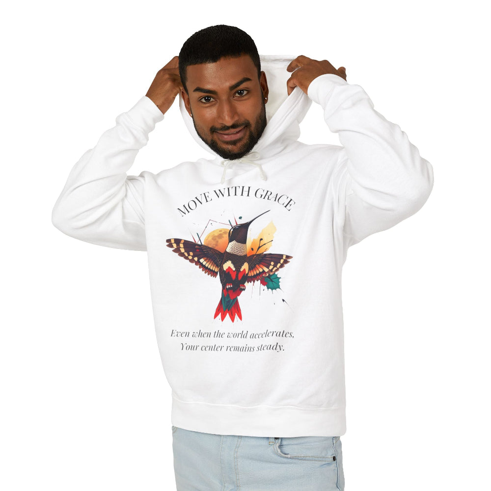 Man modeling a white hoodie with 'Move With Grace' inspirational hummingbird graphic and quote 'Even when the world accelerates, Your center remains steady' printed on the front.
