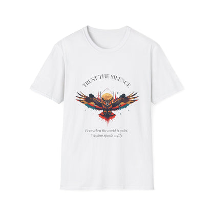 White unisex cotton t-shirt featuring bold "Trust the Silence" graphic: vibrant abstract owl with detailed feathers, intense expression, colorful geometric accents, and dynamic paint splatters in red, orange, teal, blue, and gold tones bursting outward around an orange moon background. Arched white text "TRUST THE SILENCE" above and smaller inspirational quote "Even when the world is quiet, wisdom speaks softly" below. Motivational spiritual empowerment crewneck tee.