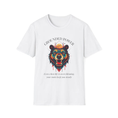 White unisex cotton t-shirt featuring bold "Grounded Power" graphic: vibrant abstract bear head portrait with intense expression, colorful geometric accents, and dynamic paint splatters in red, orange, teal, blue, and gold tones bursting outward around an orange moon background. Arched white text "GROUNDED POWER" above and smaller inspirational quote "Even when life is overwhelming, your roots keep you steady" below. Motivational spiritual empowerment crewneck tee.
