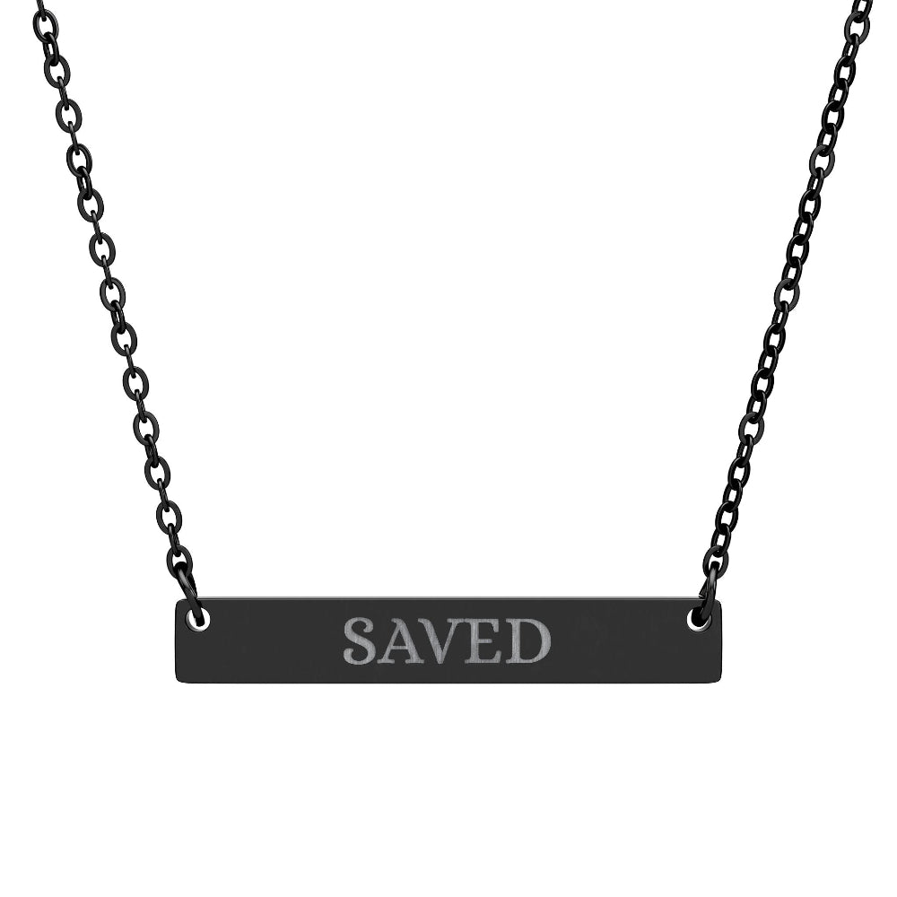Black bar necklace with engraved uppercase text "SAVED" on a matte black pendant, suspended on a delicate black chain. Minimalist motivational affirmation jewelry for grace, redemption, and spiritual protection.
