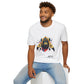 White unisex cotton t-shirt modeled by smiling man with curly hair and beard, seated pose, featuring bold Year of the Monkey zodiac graphic: vibrant abstract monkey face portrait with intense eyes, detailed fur, playful expression, geometric accents, and dynamic multicolored paint splatters in gold, red, black, blue, teal, and orange tones exploding outward. Chinese text "猴年" (Year of the Monkey) printed below in black. Zodiac Chinese New Year motivational crewneck tee.