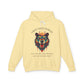 Light yellow hoodie with vibrant multicolored bear head graphic, roaring expression, fur in blue orange teal splashes, full moon above, "GROUNDED POWER" arched text, motivational quote "Even when life is overwhelming, your roots keep you steady" below