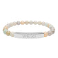 Bracelet with polished pastel beads in soft peach, cream, gray, and light blue tones with natural marbling, featuring a silver curved bar engraved "VIRGO" in uppercase letters. Stretch-fit zodiac-inspired crystal jewelry.