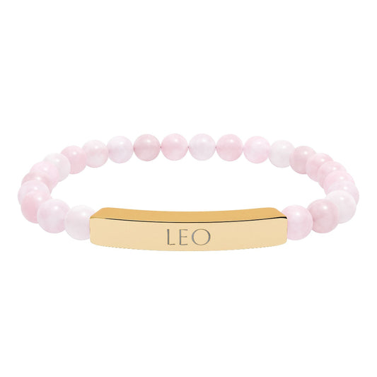 Bracelet with polished rose quartz beads in soft pink tones, natural translucent glow, paired with a gold-plated curved bar engraved "LEO" in uppercase letters. Stretch-fit zodiac-inspired crystal jewelry.