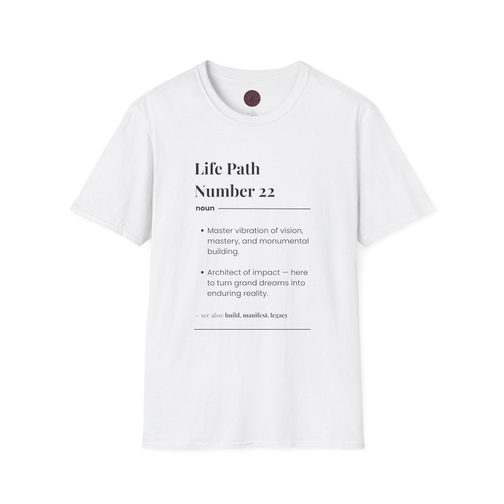 White unisex cotton t-shirt laid out flat featuring bold Life Path Number 22 numerology print in dictionary style: exact text reading "Life Path Number 22 noun · Master vibration of vision, mastery, and monumental building. · Architect of impact — here to turn grand dreams into enduring reality. – see also: build, manifest, legacy". Motivational spiritual numerology crewneck tee flat lay with visible purple/gold zodiac wheel inner tag.