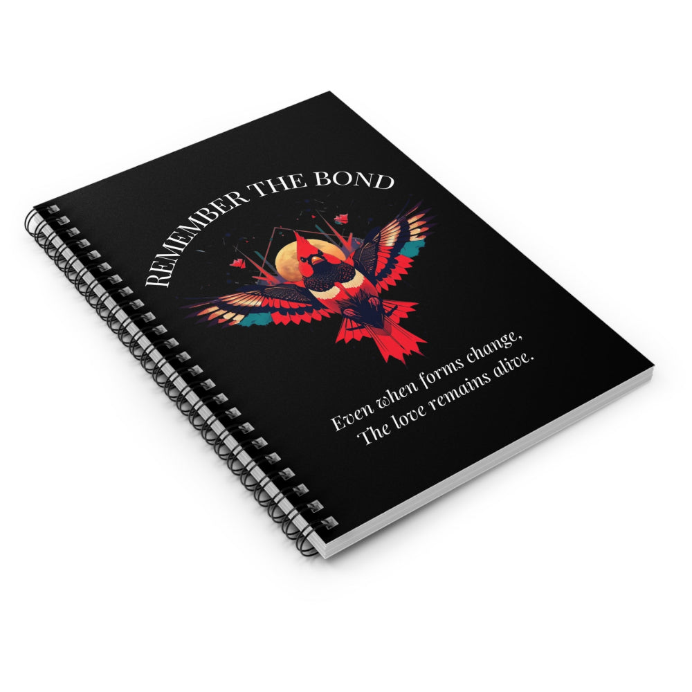 Spiral notebook with 'Remember The Bond' motivational cover design featuring a colorful bird illustration and quote 'Even when forms change, The love remains alive.' on black background.