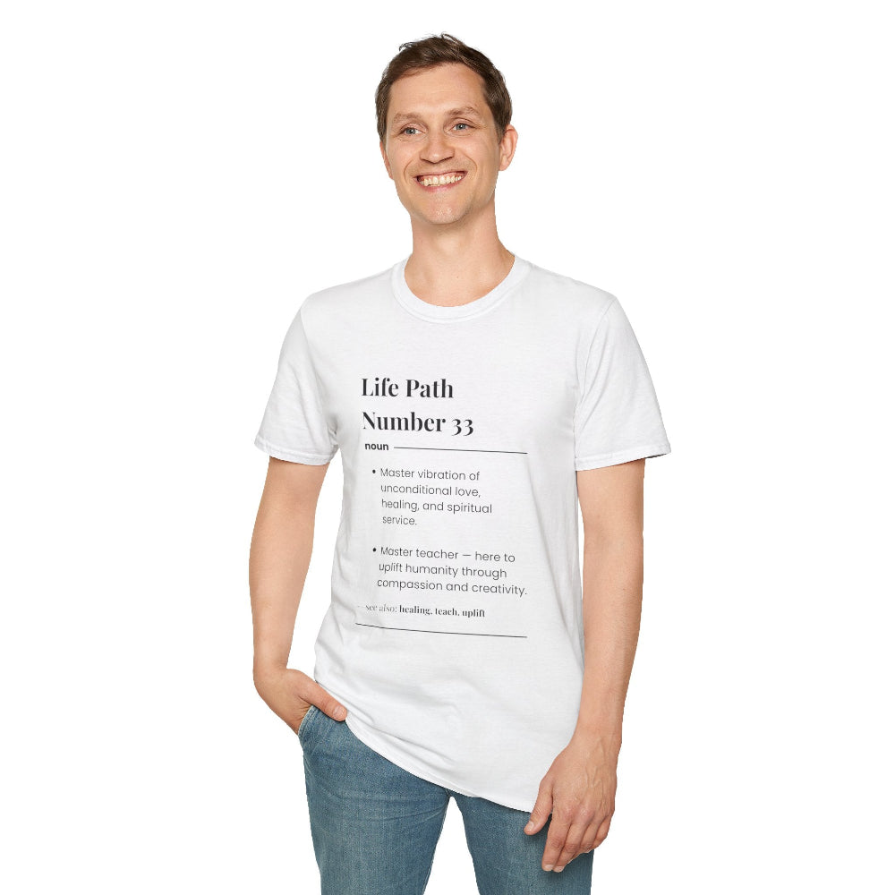 White unisex cotton t-shirt modeled by smiling man with short brown hair, featuring bold Life Path Number 33 numerology print in dictionary style: exact text reading "Life Path Number 33 noun · Master vibration of unconditional love, healing, and spiritual service. · Master teacher — here to uplift humanity through compassion and creativity. – see also: healing, teach, uplift". Motivational spiritual numerology crewneck tee.