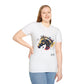 White unisex cotton t-shirt modeled by smiling plus-size female with long blonde hair, hand on hip, featuring bold Year of the Horse graphic: vibrant abstract horse head portrait with detailed mane, intense eye, bridle and harness, geometric accents, and dynamic multicolored paint splatters in gold, blue, red, black, and teal tones exploding outward. Chinese text "马年" (Year of the Horse) printed below in black. Zodiac Chinese New Year motivational crewneck tee.