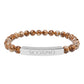 Bracelet with polished leopard jasper beads in earthy brown tones with natural veining, featuring a silver curved bar engraved "SCORPIO" in uppercase letters. Stretch-fit zodiac-inspired crystal jewelry for intensity, transformation, and emotional depth.