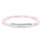Bracelet with polished rose quartz beads in soft pink tones, natural translucent glow, paired with a silver curved bar engraved "ARIES" in uppercase letters. Stretch-fit zodiac-inspired crystal jewelry.