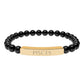 Bracelet with polished black onyx beads and gold-plated curved bar engraved "PISCES" in uppercase letters. Stretch-fit zodiac-inspired crystal jewelry.