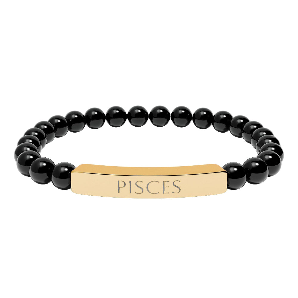 Bracelet with polished black onyx beads and gold-plated curved bar engraved "PISCES" in uppercase letters. Stretch-fit zodiac-inspired crystal jewelry.