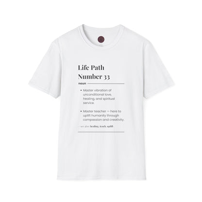 White unisex cotton t-shirt laid out flat featuring bold Life Path Number 33 numerology print in dictionary style: exact text reading "Life Path Number 33 noun · Master vibration of unconditional love, healing, and spiritual service. · Master teacher — here to uplift humanity through compassion, kindness, and creativity. – see also: healing, teach, uplift". Motivational spiritual numerology crewneck tee flat lay with visible purple/gold zodiac wheel inner tag.