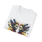 White folded unisex cotton t-shirt featuring bold Gemini zodiac graphic print: vibrant abstract twin female faces with flowing hair, intense expressions, geometric patterns, and dynamic multicolored paint splatters in gold, red, navy, teal, and black tones exploding outward to form butterfly wings. Elegant black cursive "Gemini" text below. Astrology zodiac motivational crewneck tee.