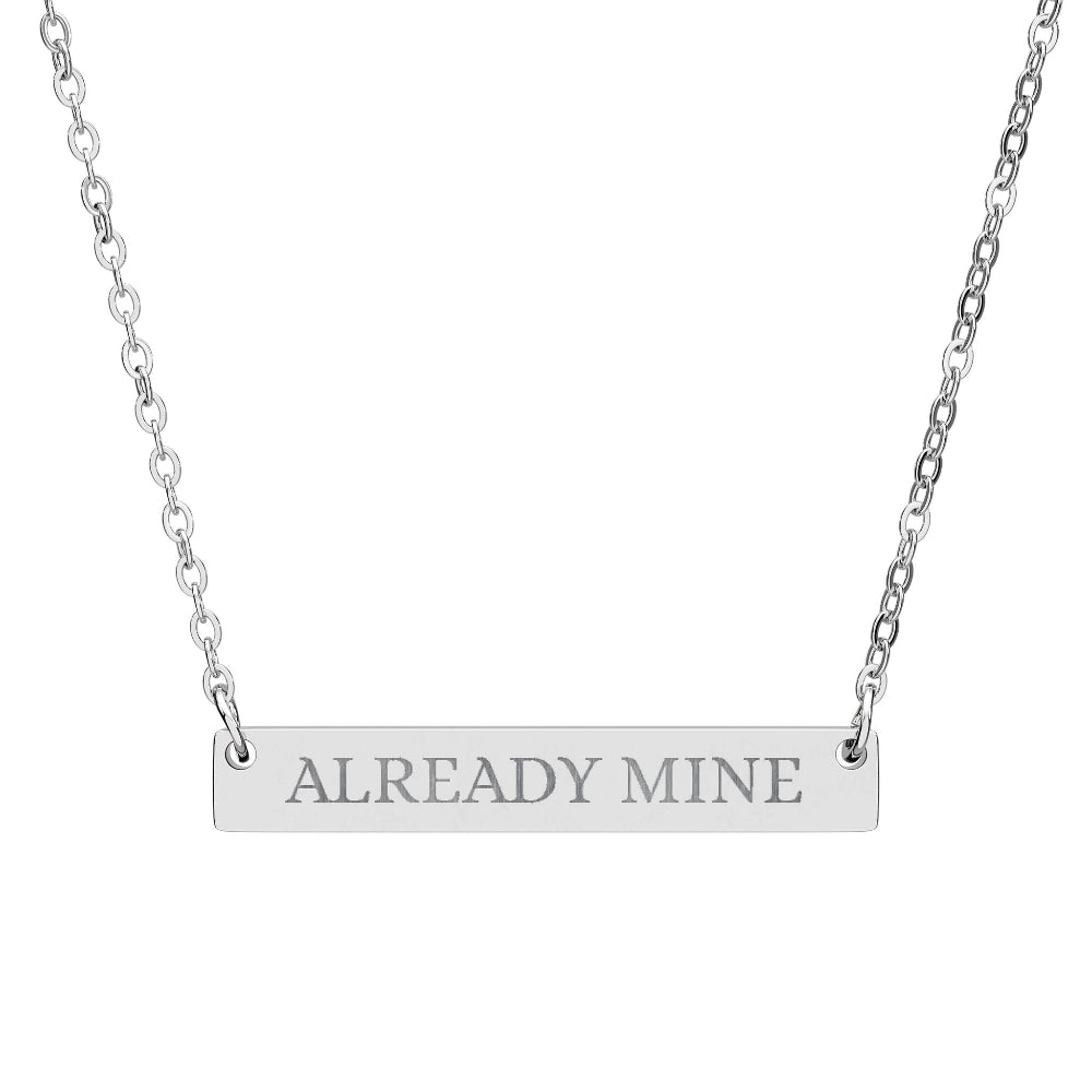 Silver bar necklace with engraved uppercase text "ALREADY MINE" on a sleek matte silver pendant, suspended on a delicate matching silver chain. Minimalist motivational affirmation jewelry for self-ownership, confidence, and empowerment.