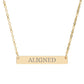 Gold bar necklace with engraved uppercase text "ALIGNED" on a sleek matte pendant, suspended on a delicate matching gold chain. Minimalist motivational affirmation jewelry for alignment, balance, and spiritual harmony.