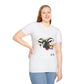 White unisex cotton t-shirt modeled by smiling plus-size female with long blonde hair, hand on hip, featuring bold Year of the Goat graphic: vibrant abstract goat head portrait with large curved horns, intense expression, geometric patterns, and dynamic multicolored paint splatters in gold, red, black, blue, teal, and orange tones exploding outward. Chinese text "羊年" (Year of the Goat) printed below in black. Zodiac Chinese New Year motivational crewneck tee.
