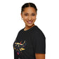 Black unisex cotton t-shirt in side profile on smiling woman with braided hair, featuring bold Taurus zodiac graphic on chest: vibrant abstract bull head portrait with large curved horns, intense expression, geometric patterns, and dynamic multicolored paint splatters in gold, red, navy, teal, and black tones exploding outward. Elegant white cursive "Taurus" text below. Astrology zodiac motivational crewneck tee.