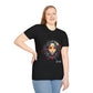 Black plus-size unisex cotton t-shirt modeled by smiling woman with braided hair, hand on cheek, featuring bold "Feral" graphic on chest: vibrant abstract portrait of a fierce woman with wild flowing hair, intense expression, tribal markings, colorful geometric accents, and dynamic paint splatters in red, orange, teal, blue, and gold tones bursting outward around an orange moon background. White elegant cursive "Feral" text below. Wild feminine energy motivational crewneck tee.