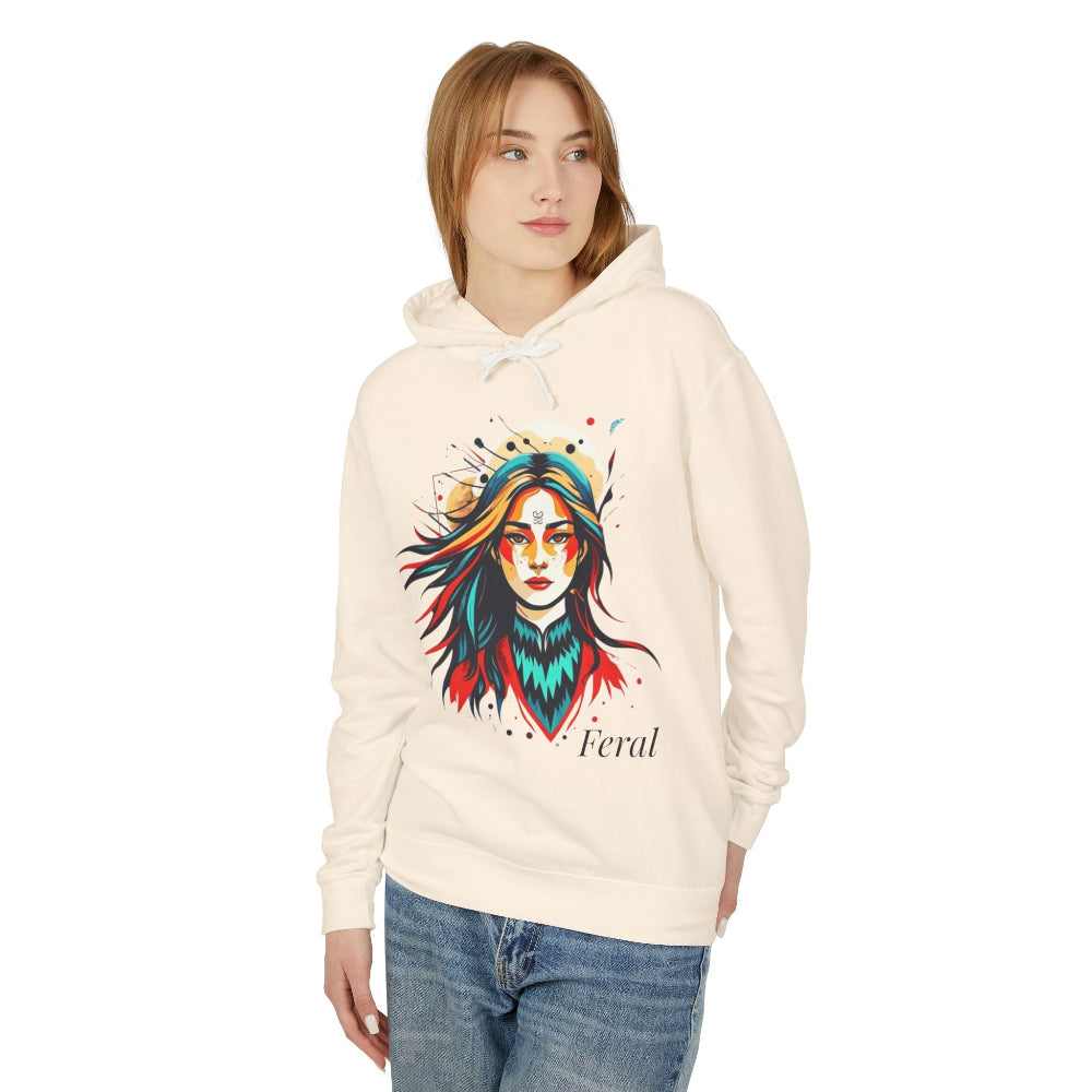 Young woman modeling cream hoodie with vibrant artistic portrait of a fierce woman with long multicolored flowing hair, teal and red face paint, colorful splash design, third-eye motif, "Feral" text below