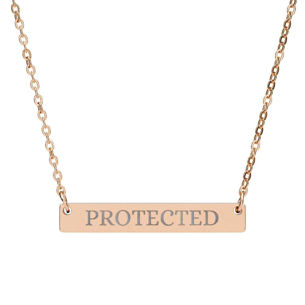 Rose gold bar necklace with engraved uppercase text "PROTECTED" on a sleek matte pendant, suspended on a delicate matching rose gold chain. Minimalist motivational affirmation jewelry for protection and empowerment.
