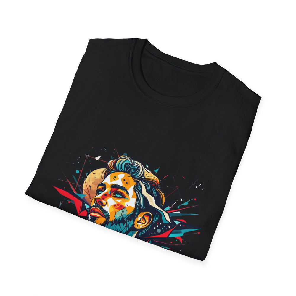Black folded unisex cotton t-shirt featuring bold Primal graphic print: stylized bearded man portrait with stylish hair, intense upward gaze, and vibrant multicolored geometric shards in red, yellow, teal, and blue exploding outward. Primal masculine energy motivational crewneck tee.