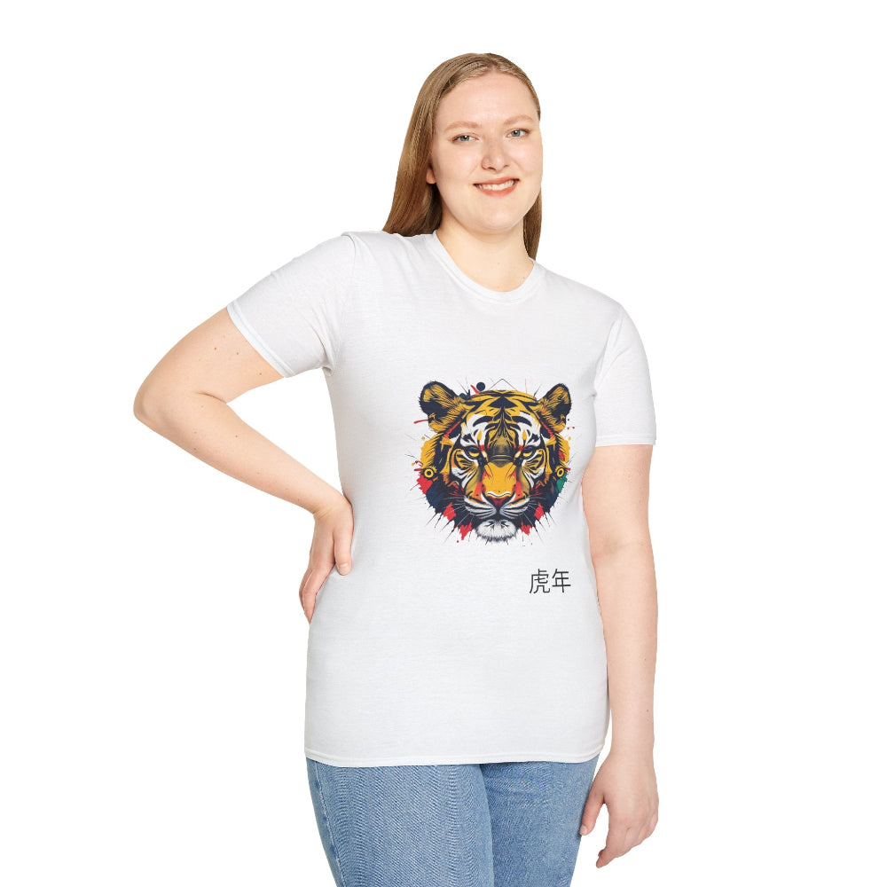 White unisex cotton t-shirt modeled by smiling plus-size female with long blonde hair, hand on hip, featuring bold Year of the Tiger graphic: vibrant abstract tiger face portrait with fierce eyes, detailed stripes, geometric patterns, and dynamic multicolored paint splatters in yellow, orange, red, blue, and black tones exploding outward. Chinese text "虎年" (Year of the Tiger) printed below in black. Zodiac Chinese New Year motivational crewneck tee.