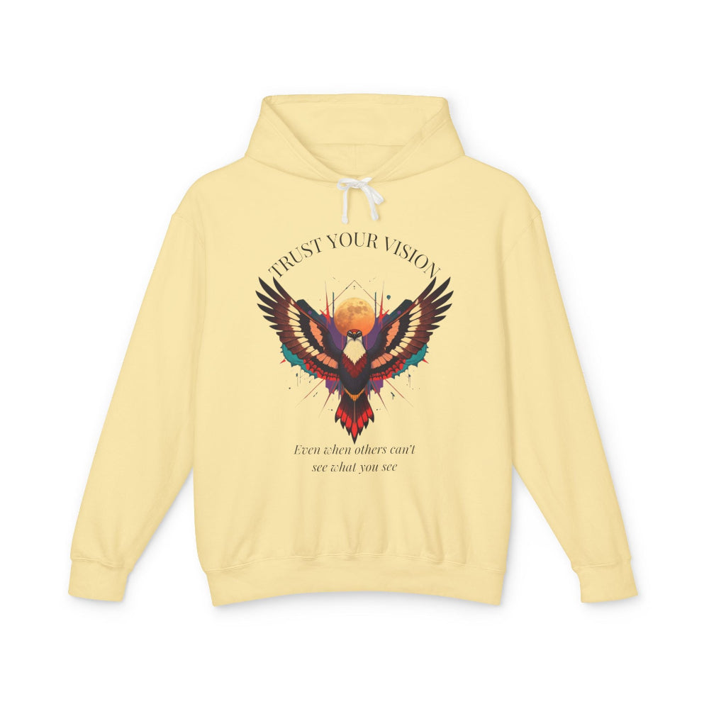 Light yellow hoodie featuring colorful abstract eagle/phoenix graphic with moon background, "TRUST YOUR VISION" arched above, and inspirational quote "Even when others can't see what you see" below