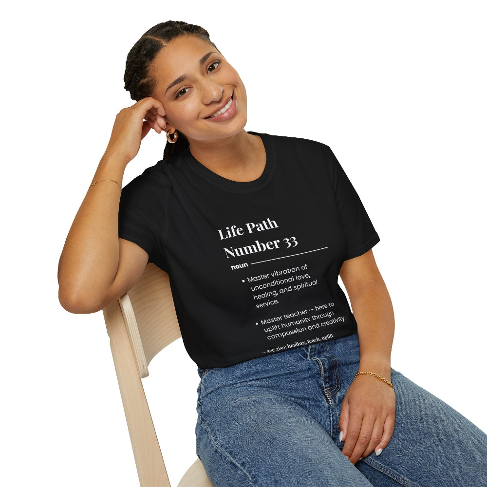 Black unisex cotton t-shirt modeled by smiling woman with braided hair, hand on cheek, featuring bold Life Path Number 33 numerology print in dictionary style: exact text reading "Life Path Number 33 noun · Master vibration of unconditional love, healing, and spiritual service. · Master teacher — here to uplift humanity through compassion, kindness, and creativity. – see also: healing, teach, uplift". Motivational spiritual numerology crewneck tee.
